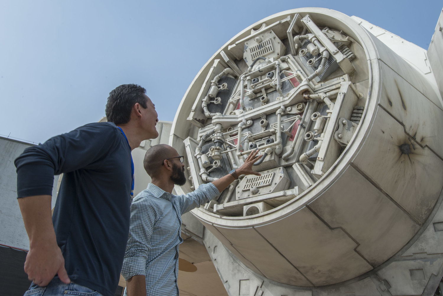 Imagineers looking at the Millennium Falcon at Star Wars: Galaxy's Edge.