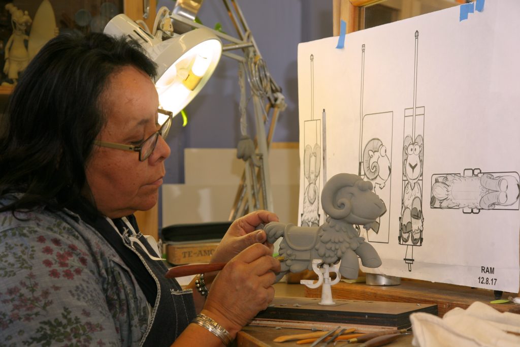 Imagineer sculpting a character for an attraction.