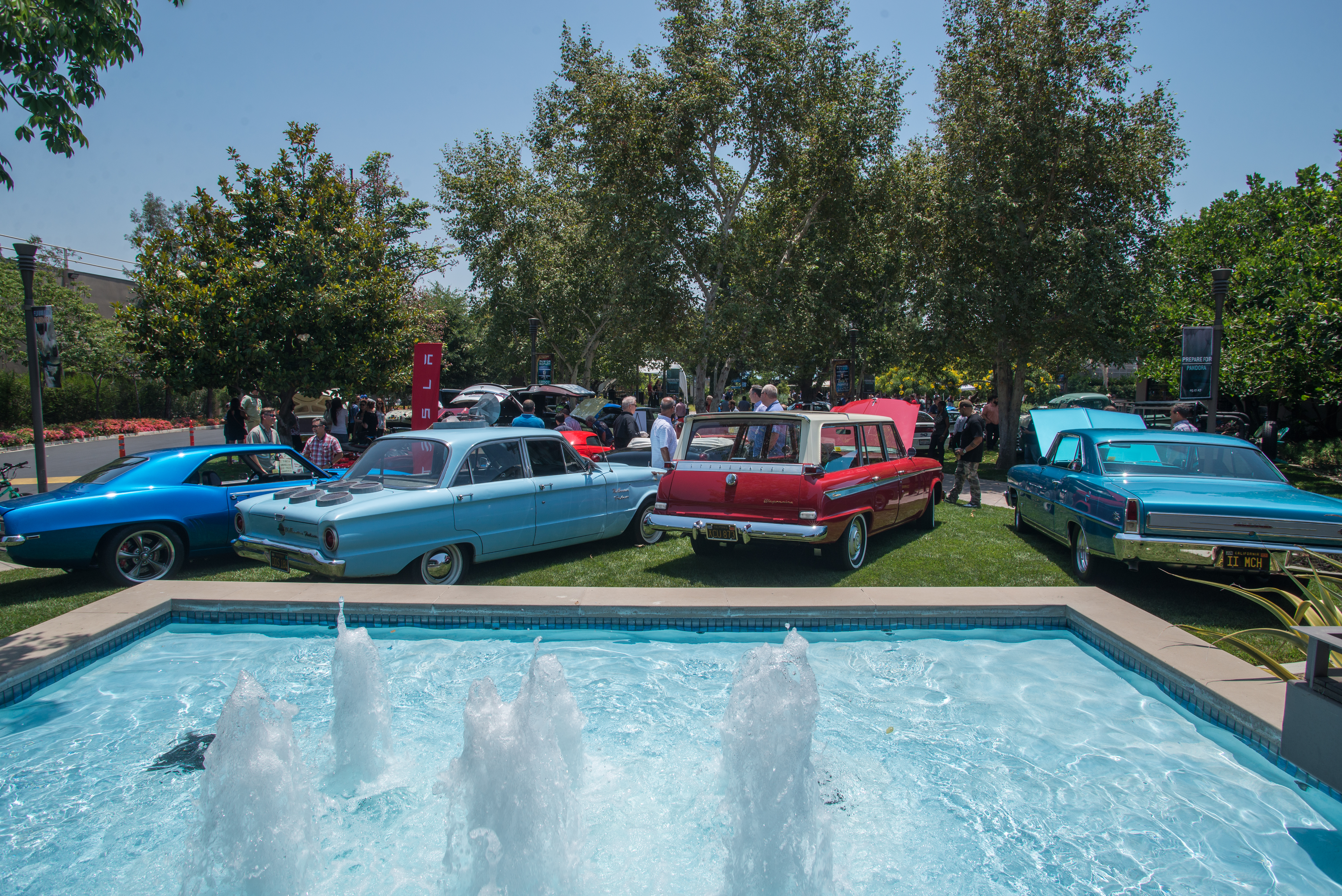 Imagineers exploring different classic cars at WDI's Car Show.
