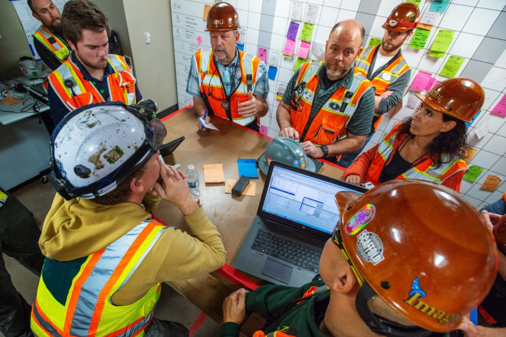 Imagineers have a meeting in the field.