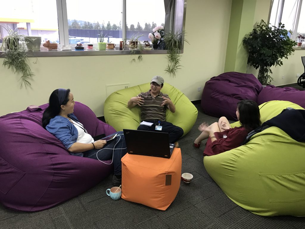 Imagineers having an informal meeting on bean bag chairs.