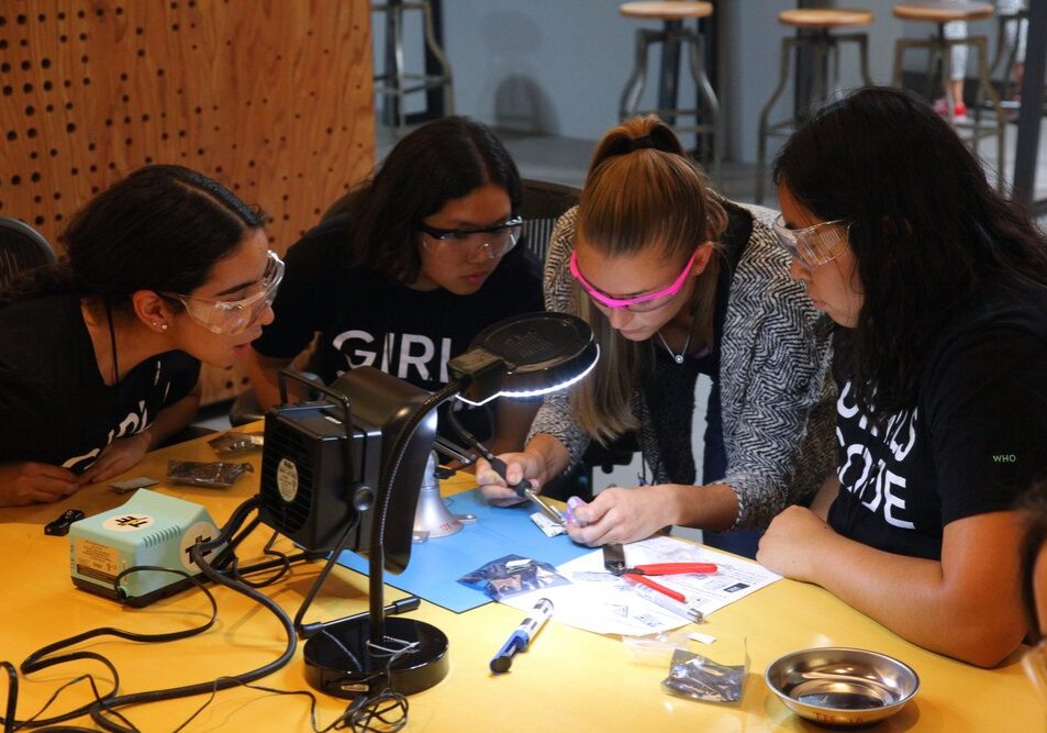Girls who Code participants practicing soldering during WDI tour.