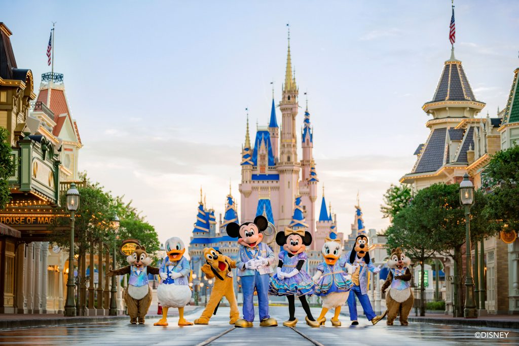 Mickey Mouse, Minnie Mouse, and other Disney characters posing in the middle of Main Street at Walt Disney World