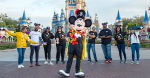 Drum Major Mickey in front of Cinderella Castle at the Walt Disney World Resort with a group of Disney Aspire team members