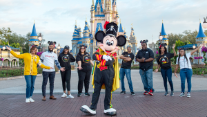 Drum Major Mickey in front of Cinderella Castle at the Walt Disney World Resort with a group of Disney Aspire team members