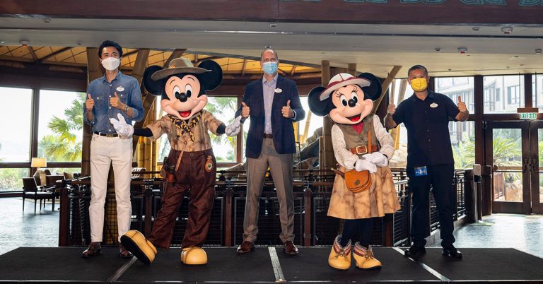 Joseph Yip with two team members and Mickey and Minnie