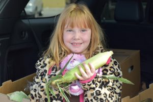 Child holding an ear of corn