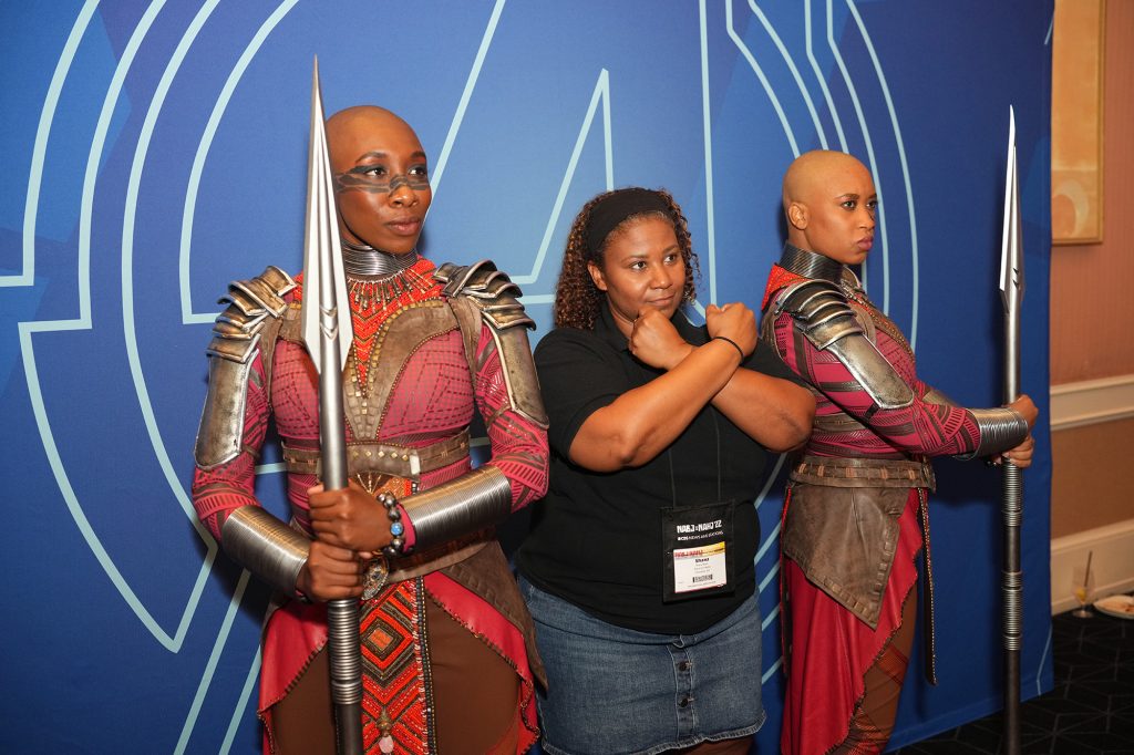 A guest poses with the fierce warriors of Dora Milaje from Marvel’s “Black Panther”