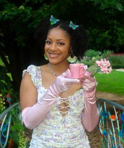 TaBria Donkor on a bridge holding a pink teacup
