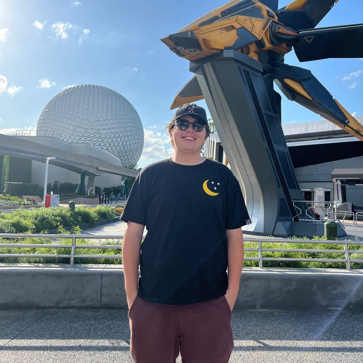 Male Disney College Program participate smiling while standing in front of the new Guardians of the Galaxy Cosmic Rewind ride at EPCOT