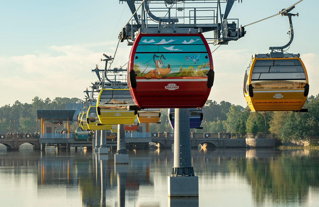 Disney-themed gondolas of the Skyliner Gondola sitting above the water at the Walt Disney World Resort