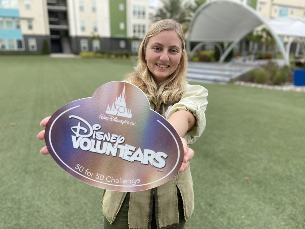 Kelsey Leaf holds the Disney 50 for 50 VoluntEAR iridescent commemorative nametag