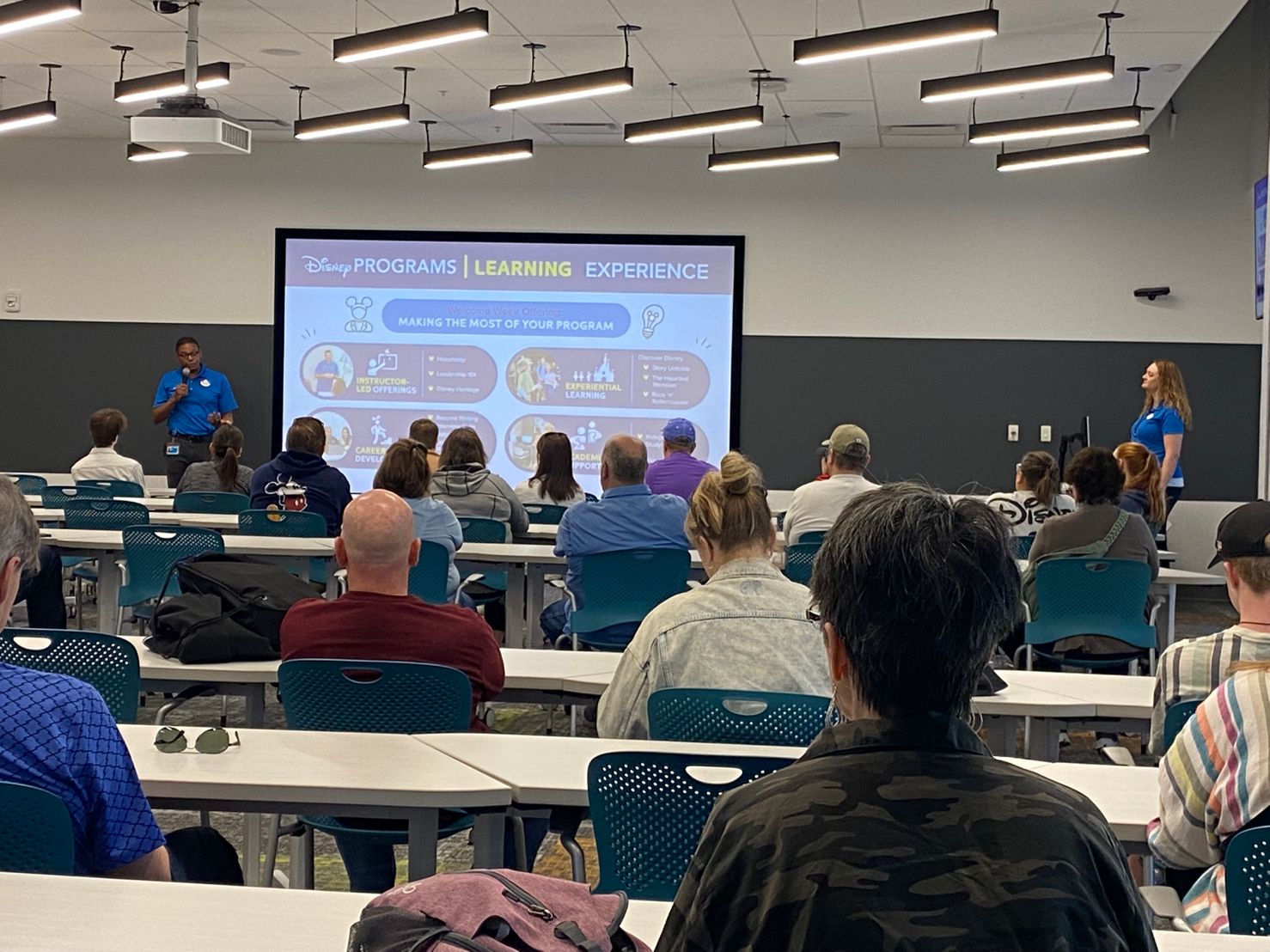 Group of attendees watching a Disney Programs Learning Experience presentation