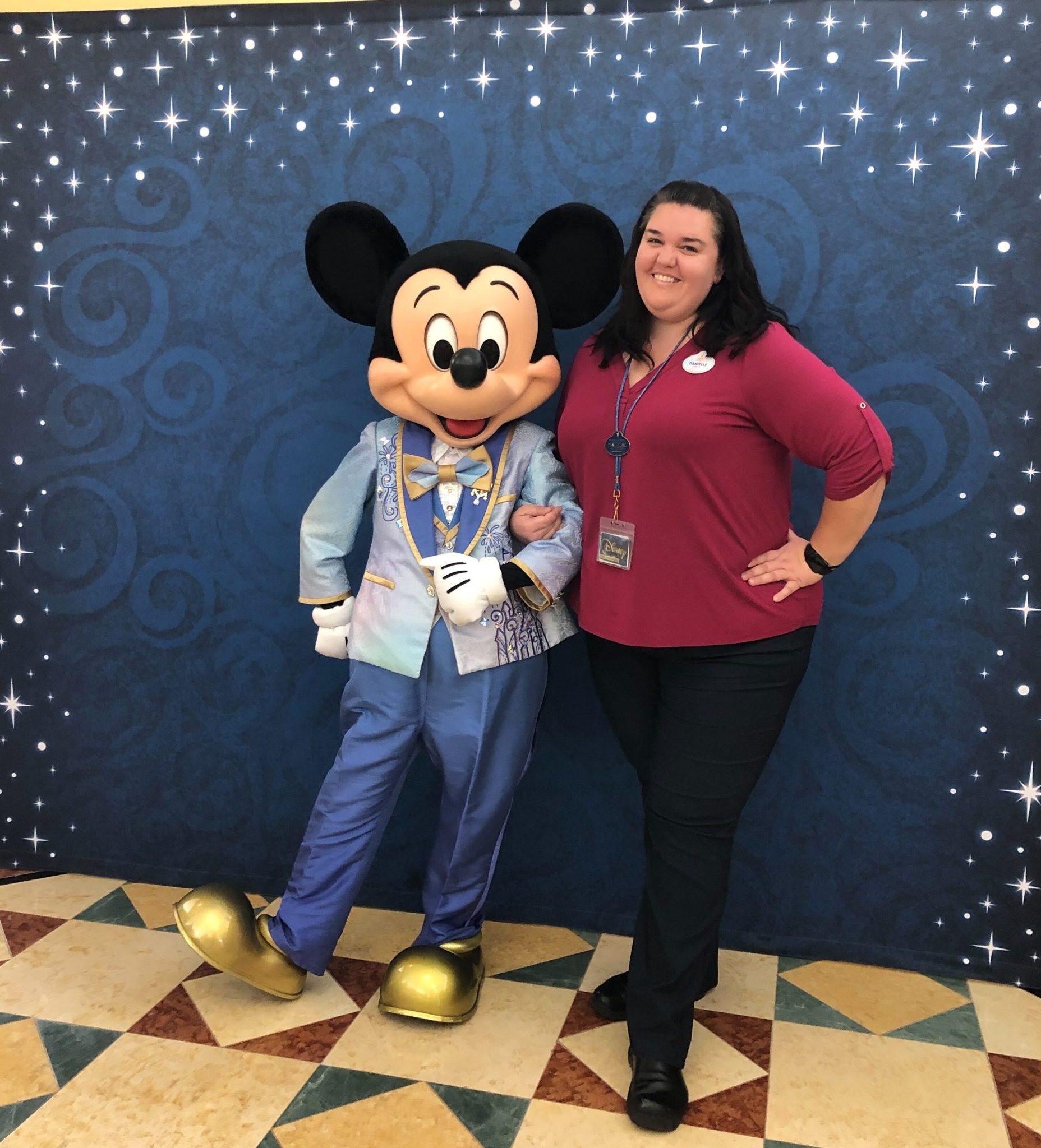 Disney DPEP Technology and Digital Employee Danielle wearing a red long sleeve shirt and smiling with Mickey Mouse