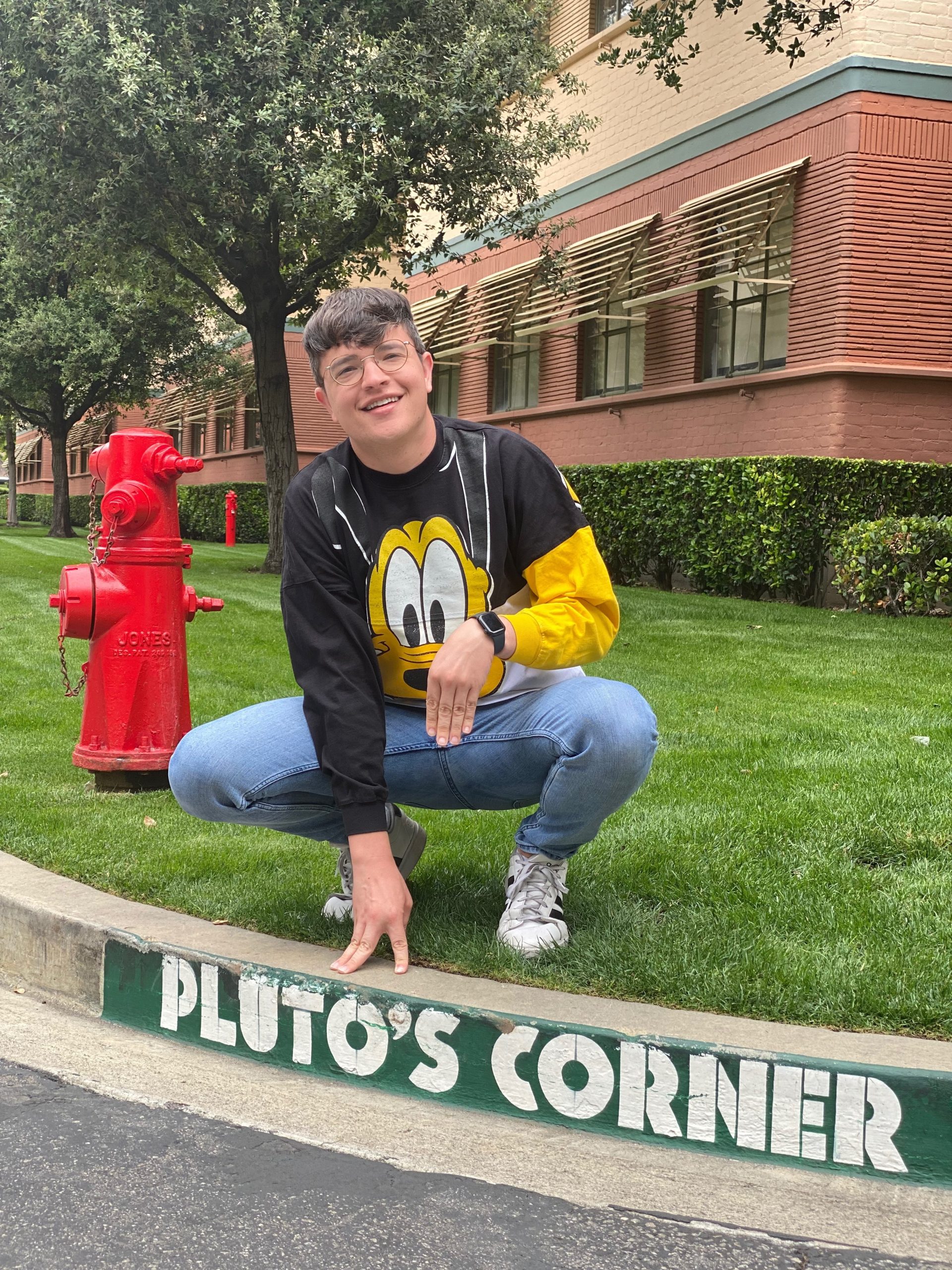 Walt Disney World performer Cullen wearing a Pluto sweatshirt at Pluto's Corner on the Walt Disney Studios Lot.