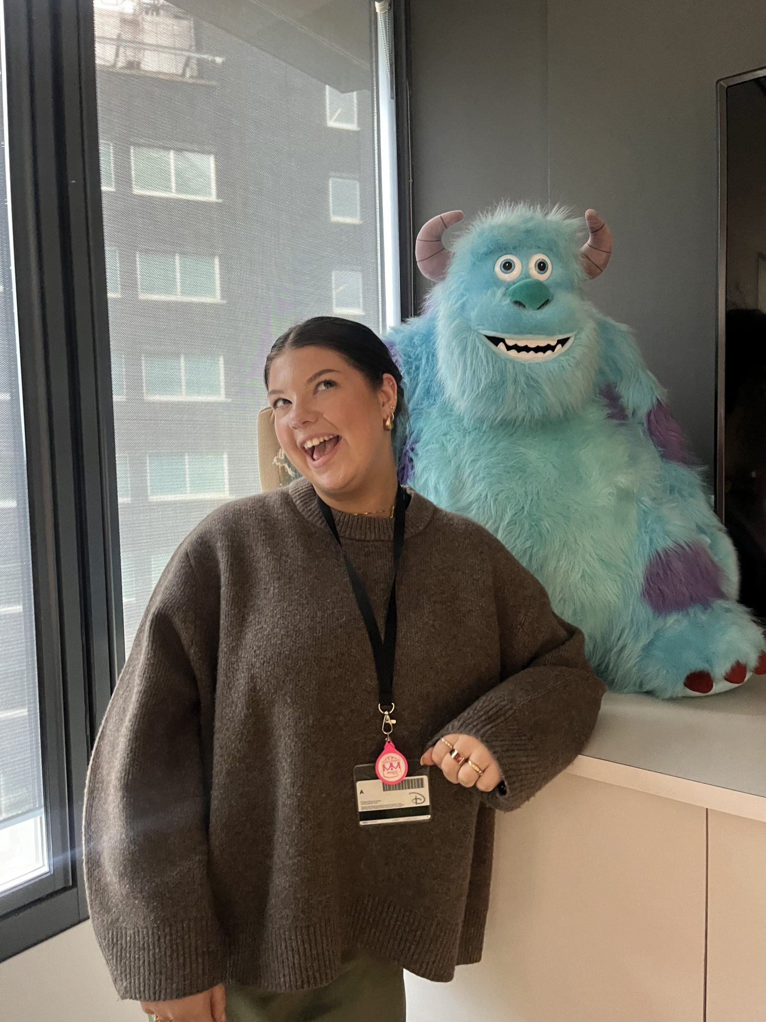 Photo of Ellen, Disney+ Marketing and Publicity Intern, in front of Sulley stuffed animal figure from Monsters, Inc.