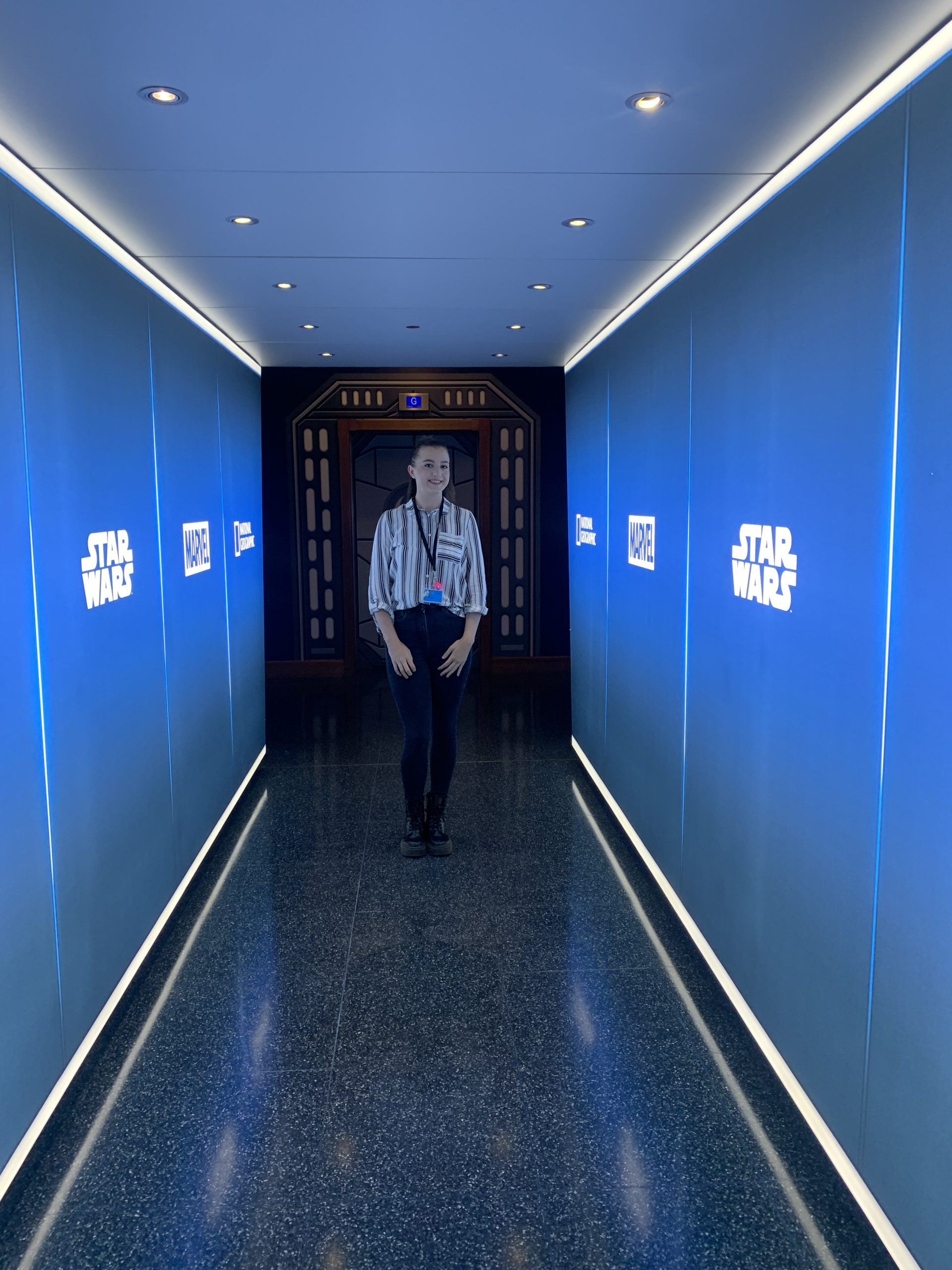 Photo of Karla, Marketing and Publicity Intern for The Walt Disney Studios, in a hallway with Studios logos.