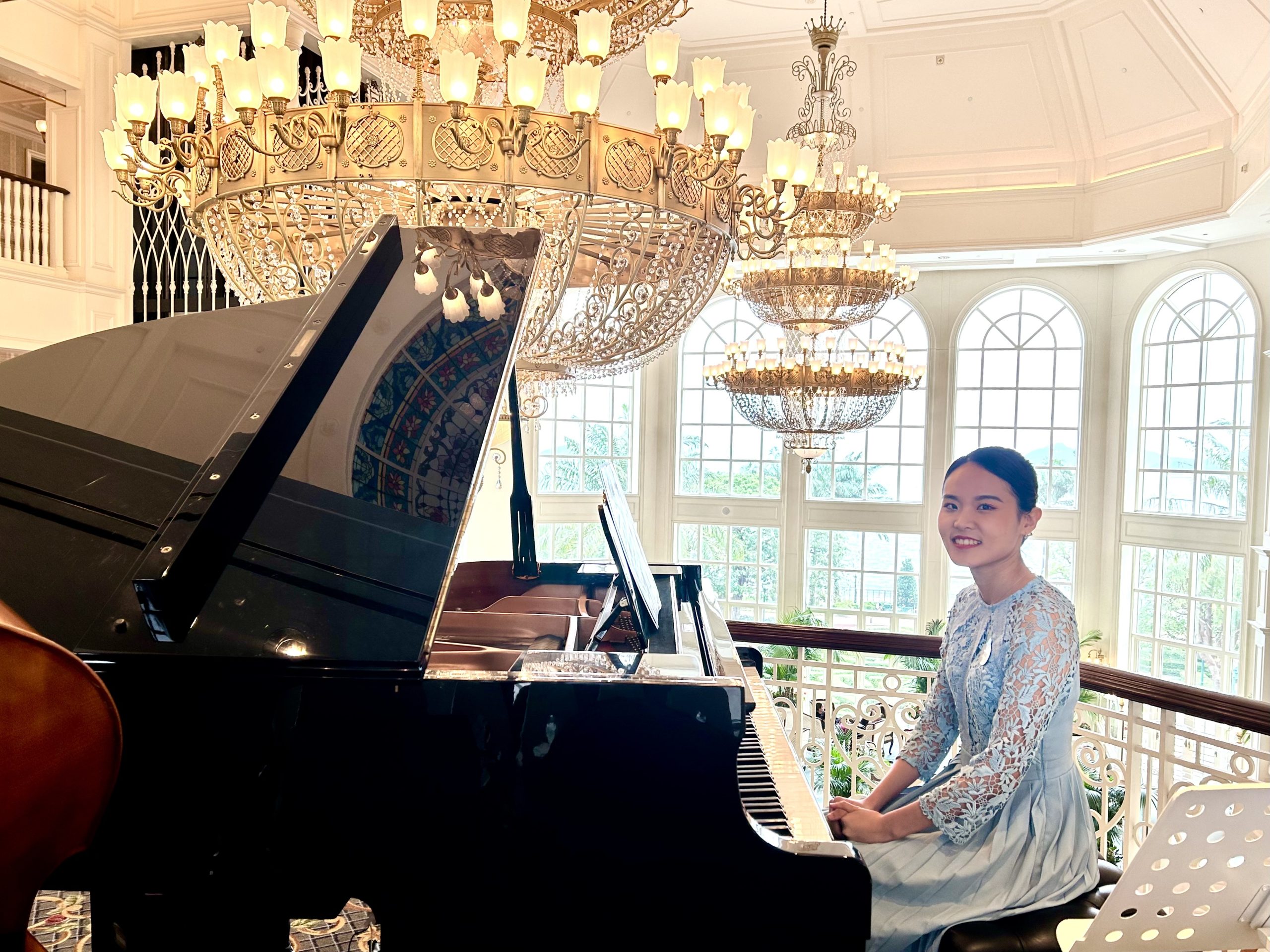 Natalie Yen posing for a photo, sitting at a piano