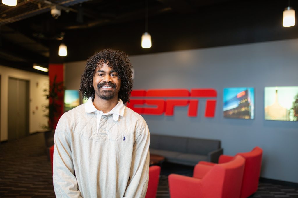 Lenny smiles in front of an ESPN sign