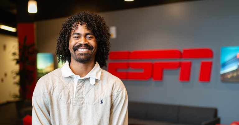 Lenny smiles in front of an ESPN sign