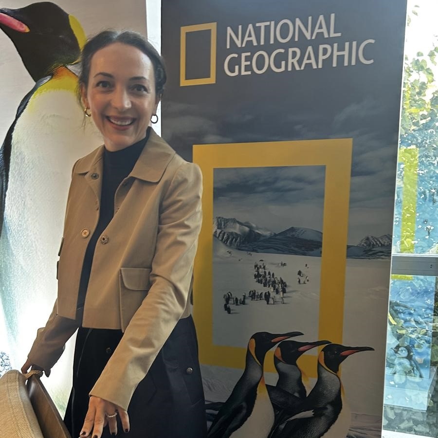 Basak 07 woman posing in front of National Geographic penguin banner