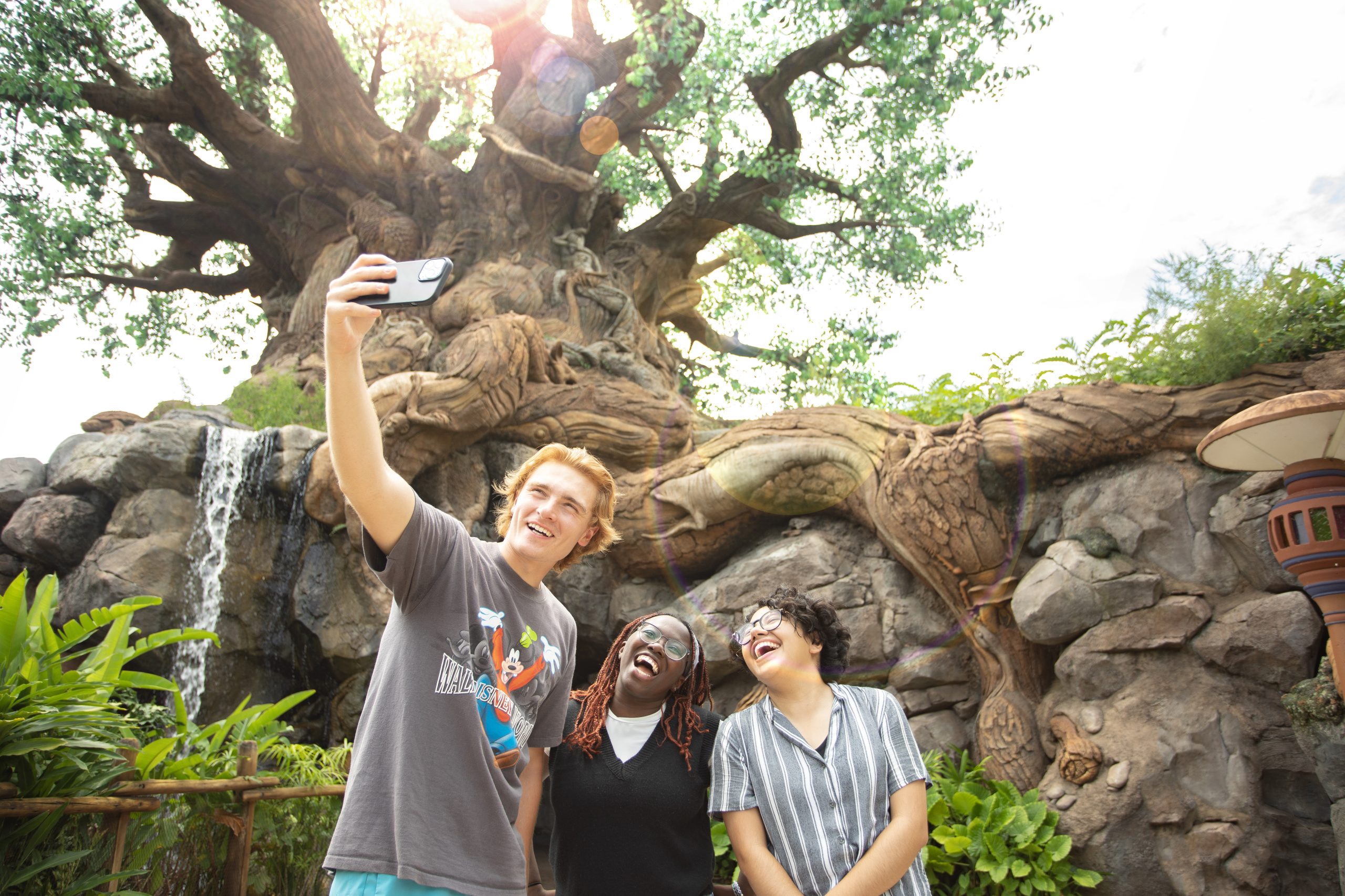 trio taking a selfie in front of the Tree of Life in Disney's Animal Kingdom