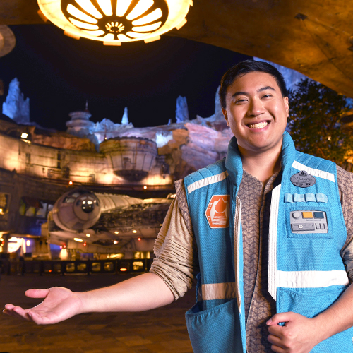 man posing in front of the Millennium Falcon in Star Wars: Galaxy's Edge