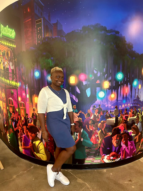 A person stands in front of a vibrant mural