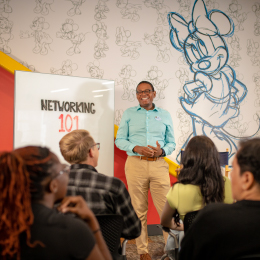 man speaking in front of people during a learning offering