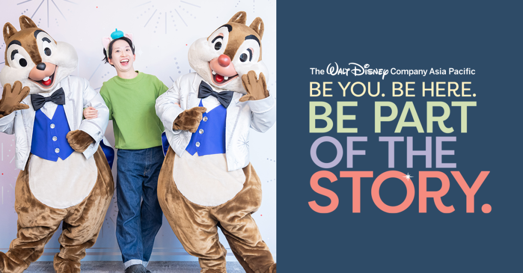 A woman posing with Chip and Dale next to a graphic that reads "Be You Be Here Be Part Of the Story"
