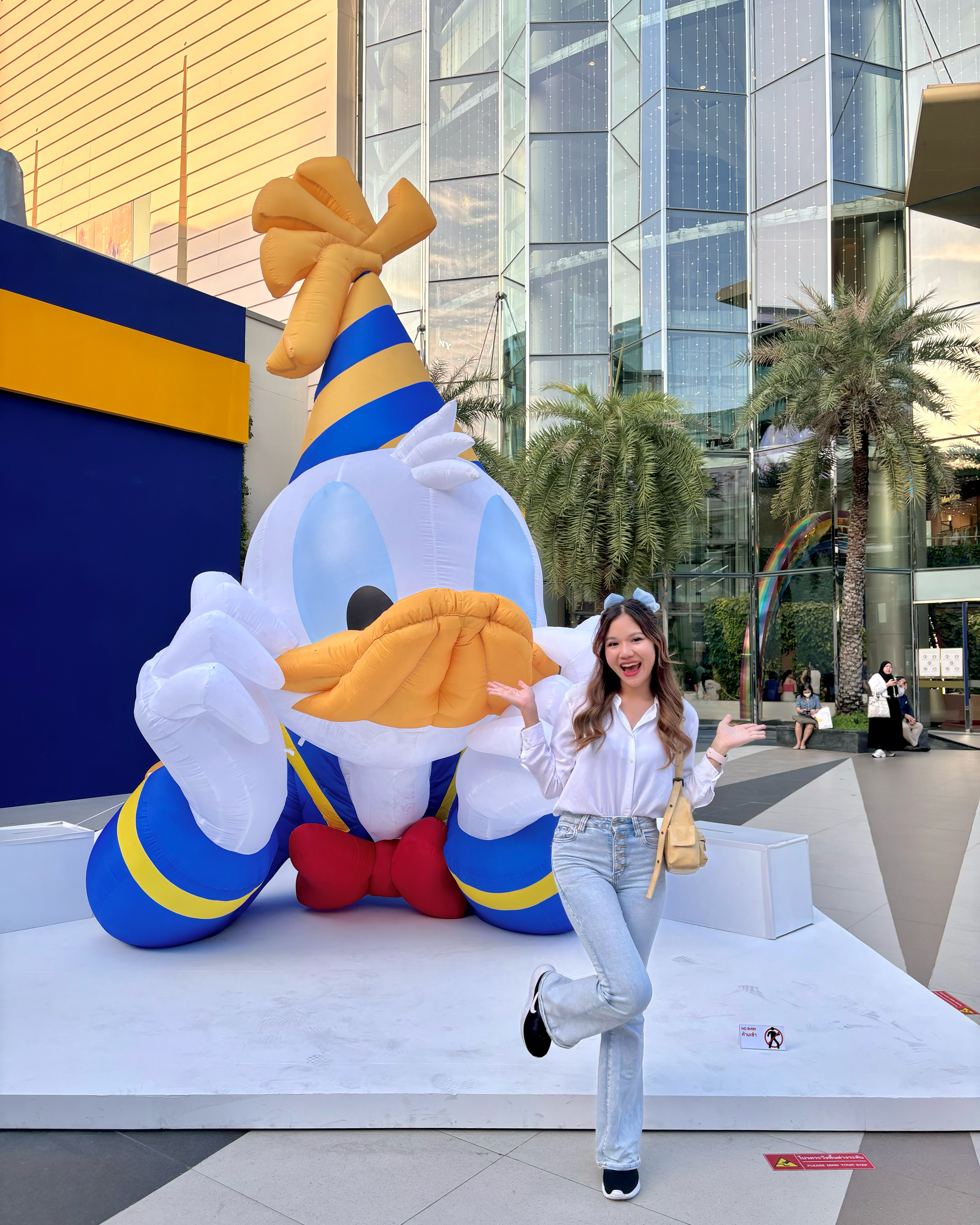 Person posing in front of a giant inflatable Donald Duck.
