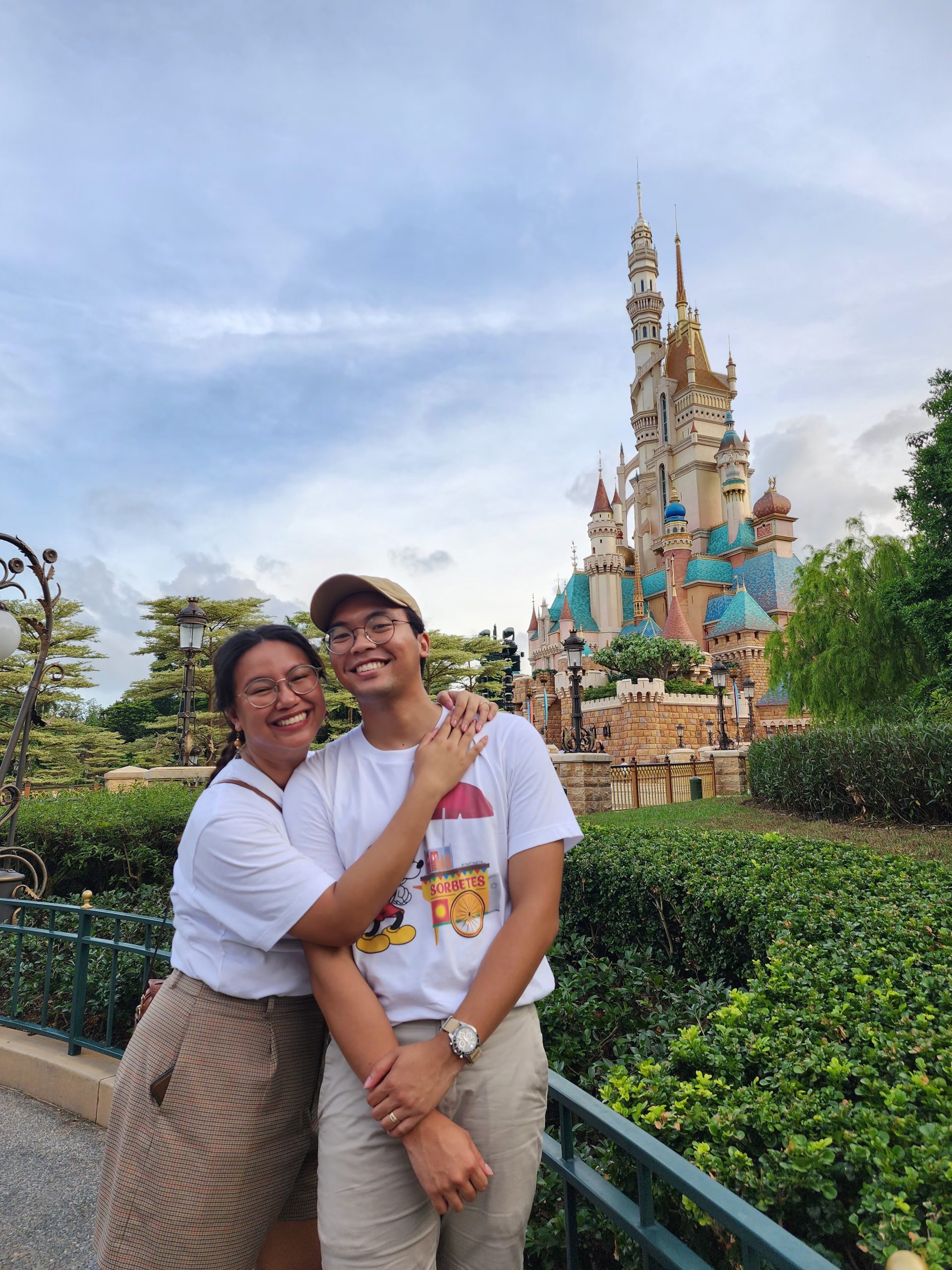 Bryan and partner standing in front of Castle of Magical Dreams in Hong Kong Disney Land