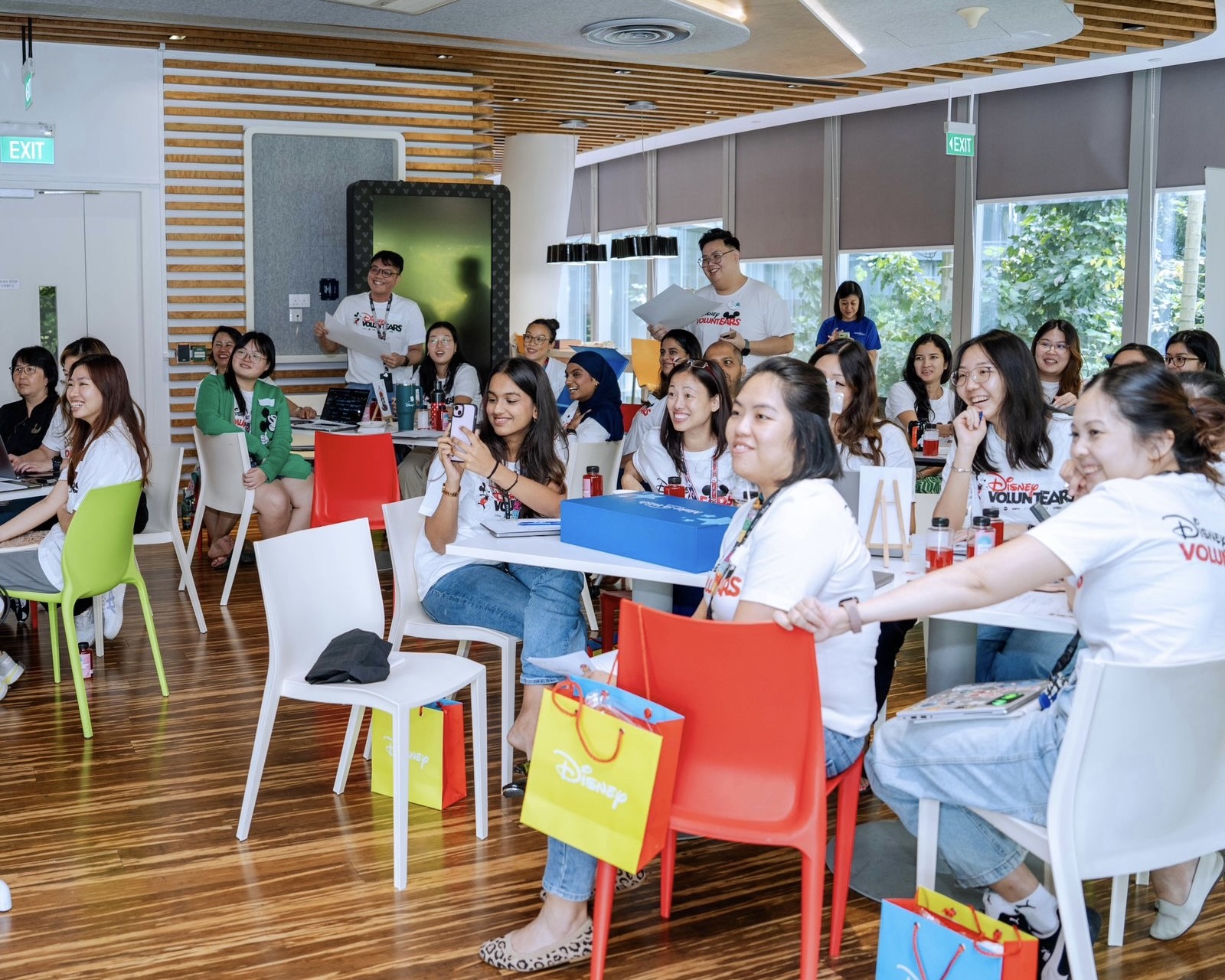 B3D2A371-3709-45C4-99F6-A4C045079B8B_1_201_a Six people take a selfie at a lively event surrounded by attendees and tables filled with food.