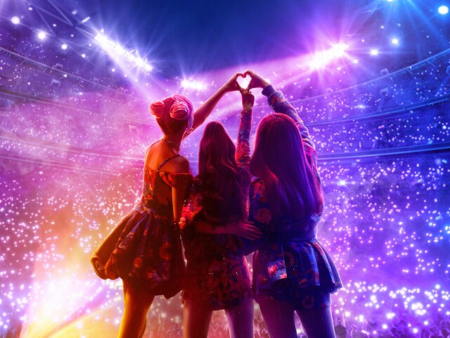 electric bloom Cast of Electric Bloom posing in front of an audience and holding up a heart hands symbol