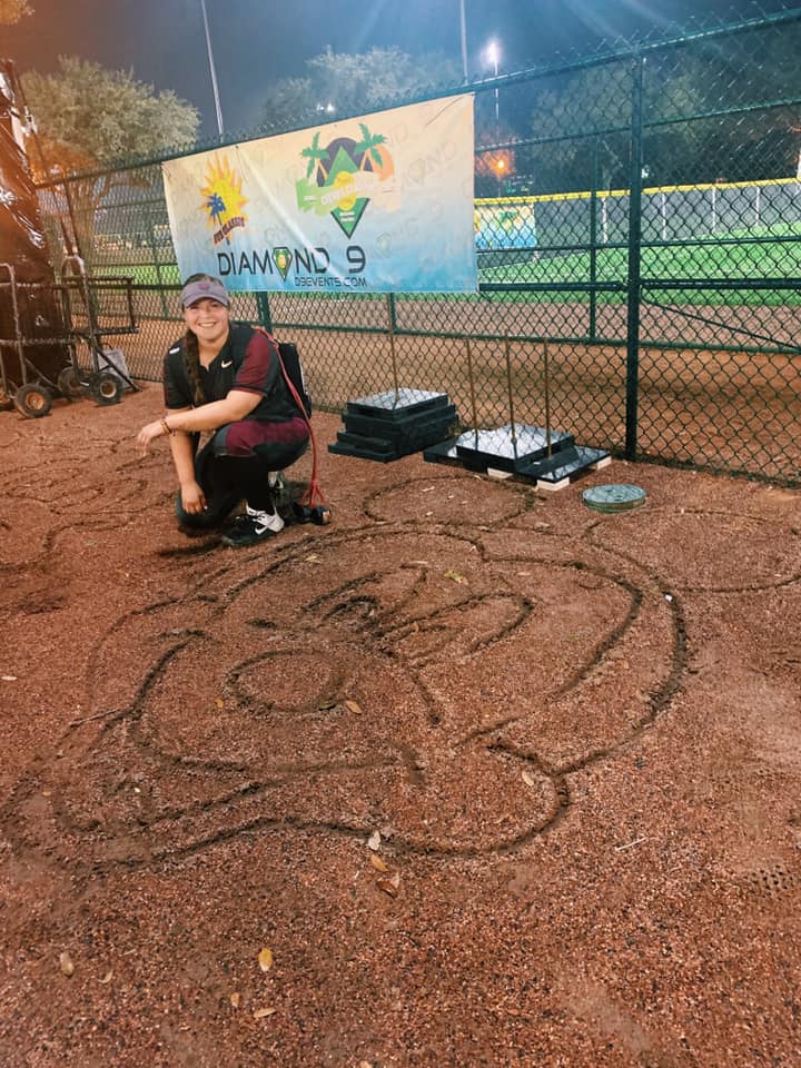 Destiny on softball field posing with drawing of Mickey Mouse