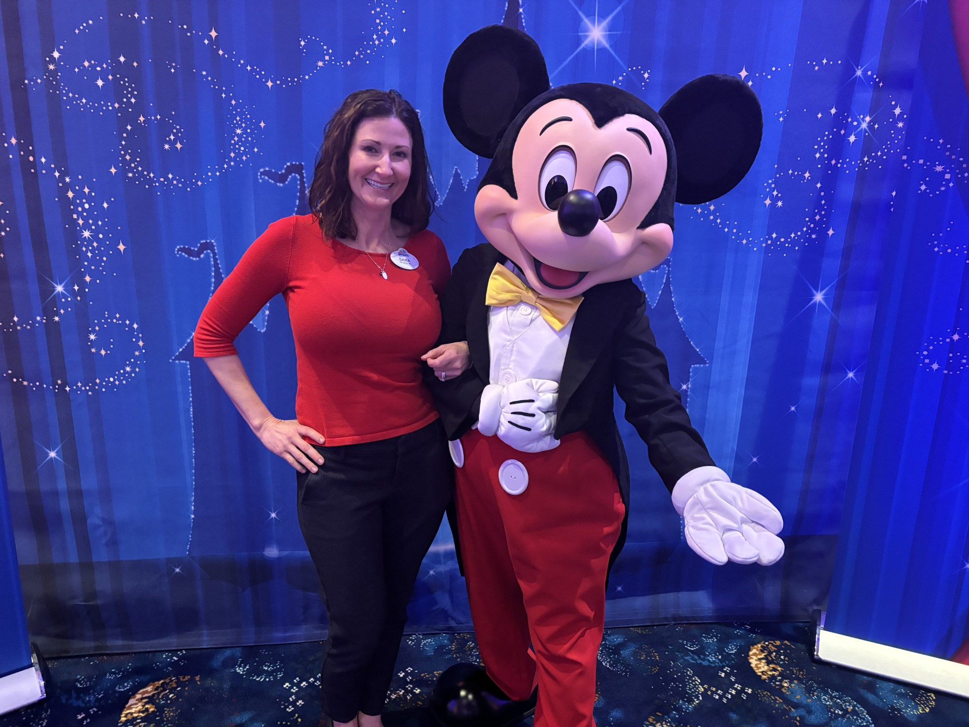 Sara and Mickey Mouse smile side by side.