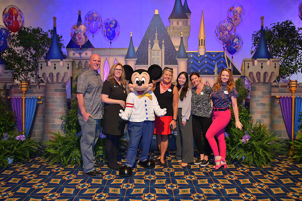 Sara and her team proudly pose with Mickey.