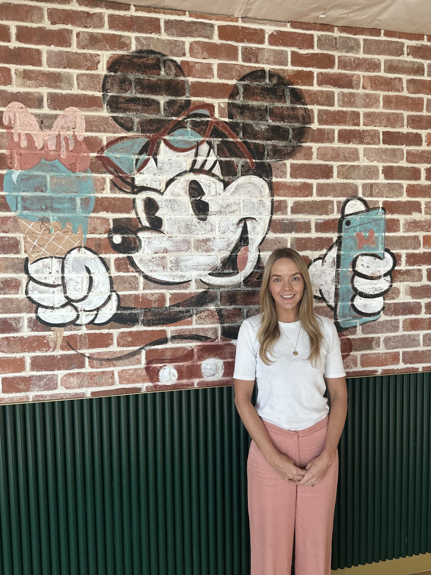 Mimi posing in front of Minnie Mouse wall art.