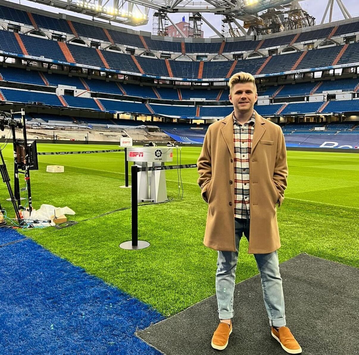 Person standing on a soccer field inside a stadium