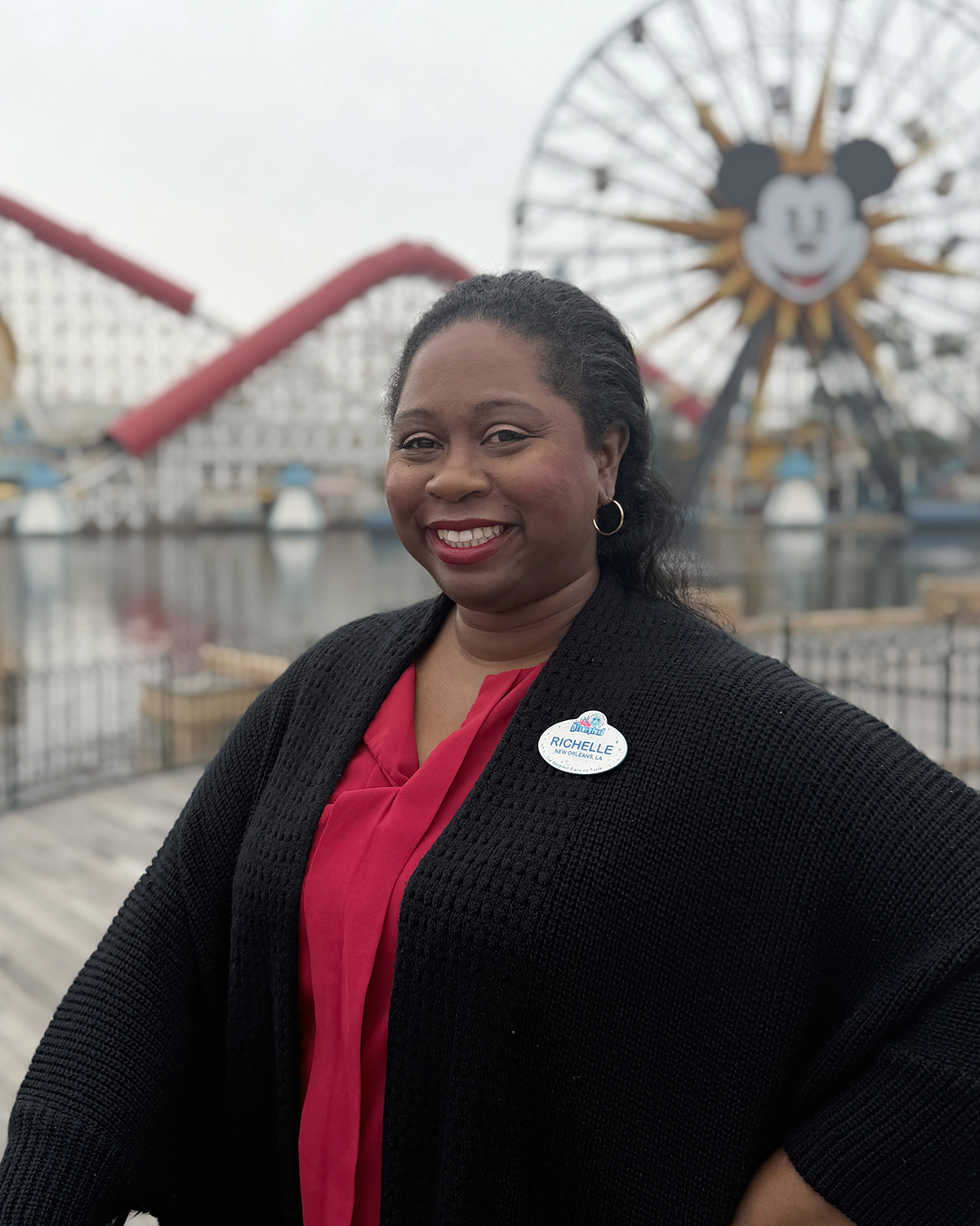 Disney cast member at Disney California Adventure Park with Pixar Pal‑A‑Round in the background, reflecting guest service and leadership roles at Disneyland Resort.