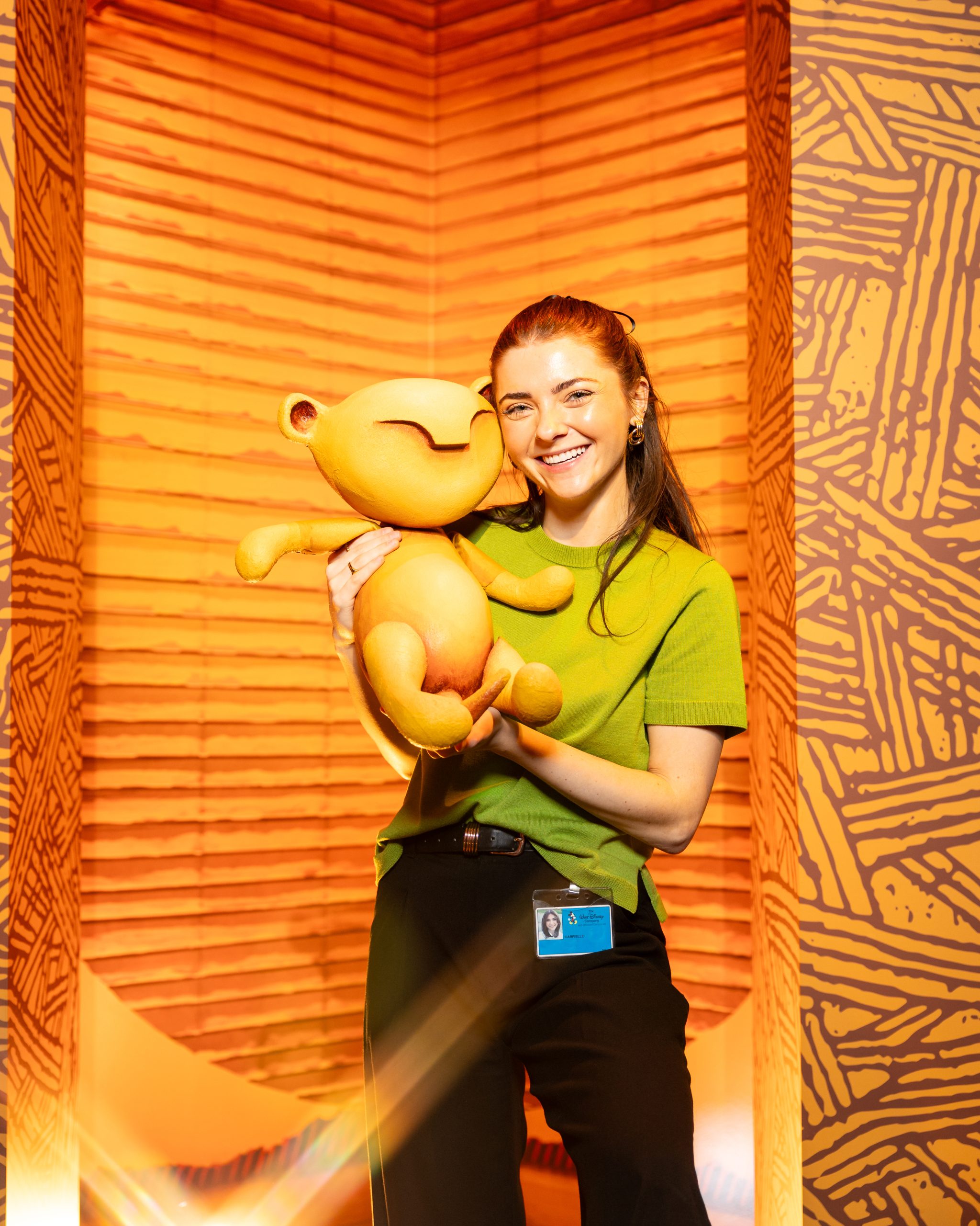 Disney cast member holding a character puppet, highlighting immersive storytelling and content creation inside Disney on Broadway.