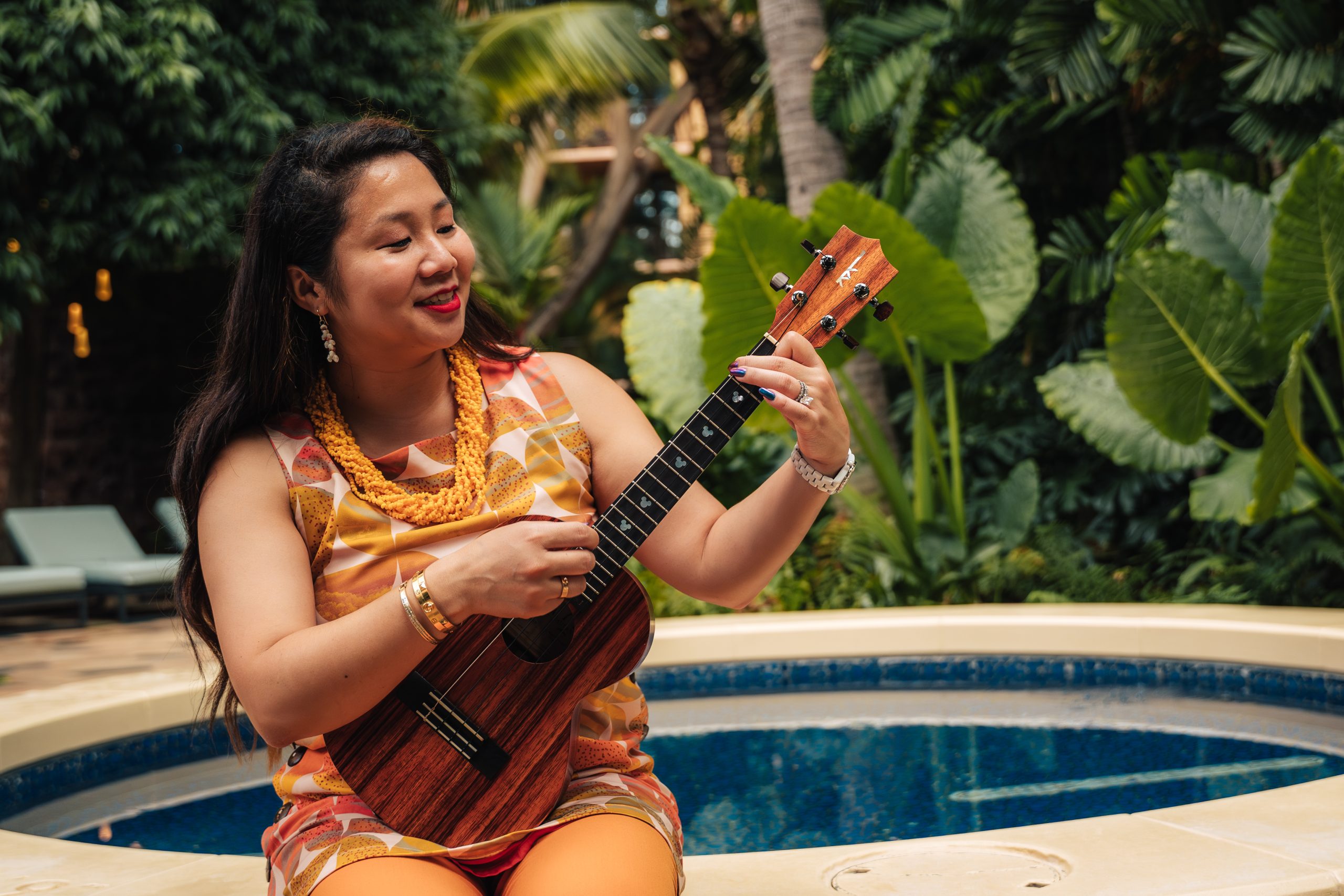 Dylan playing ukulele by a pool