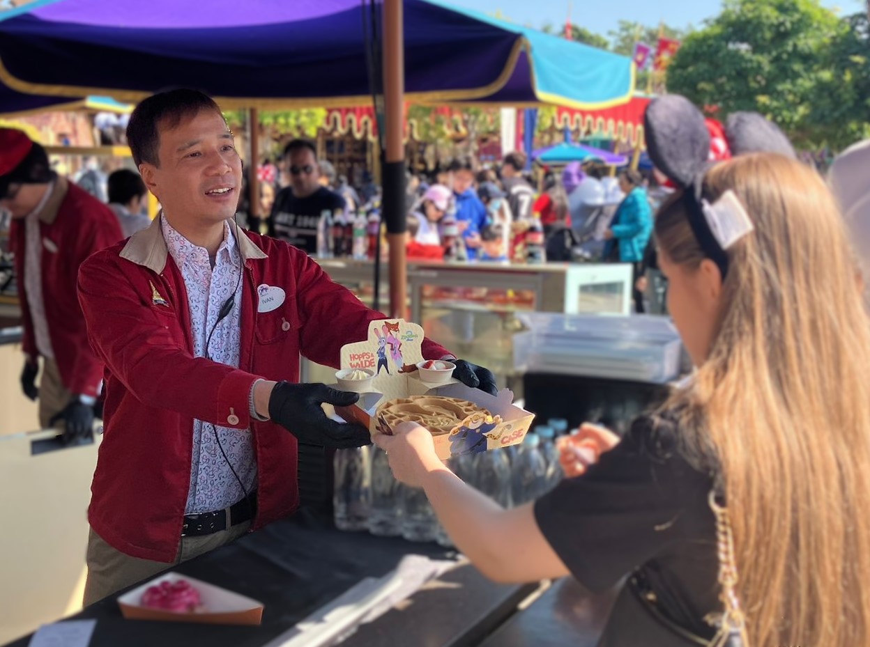 Image of food and beverage employee handing item to guest.