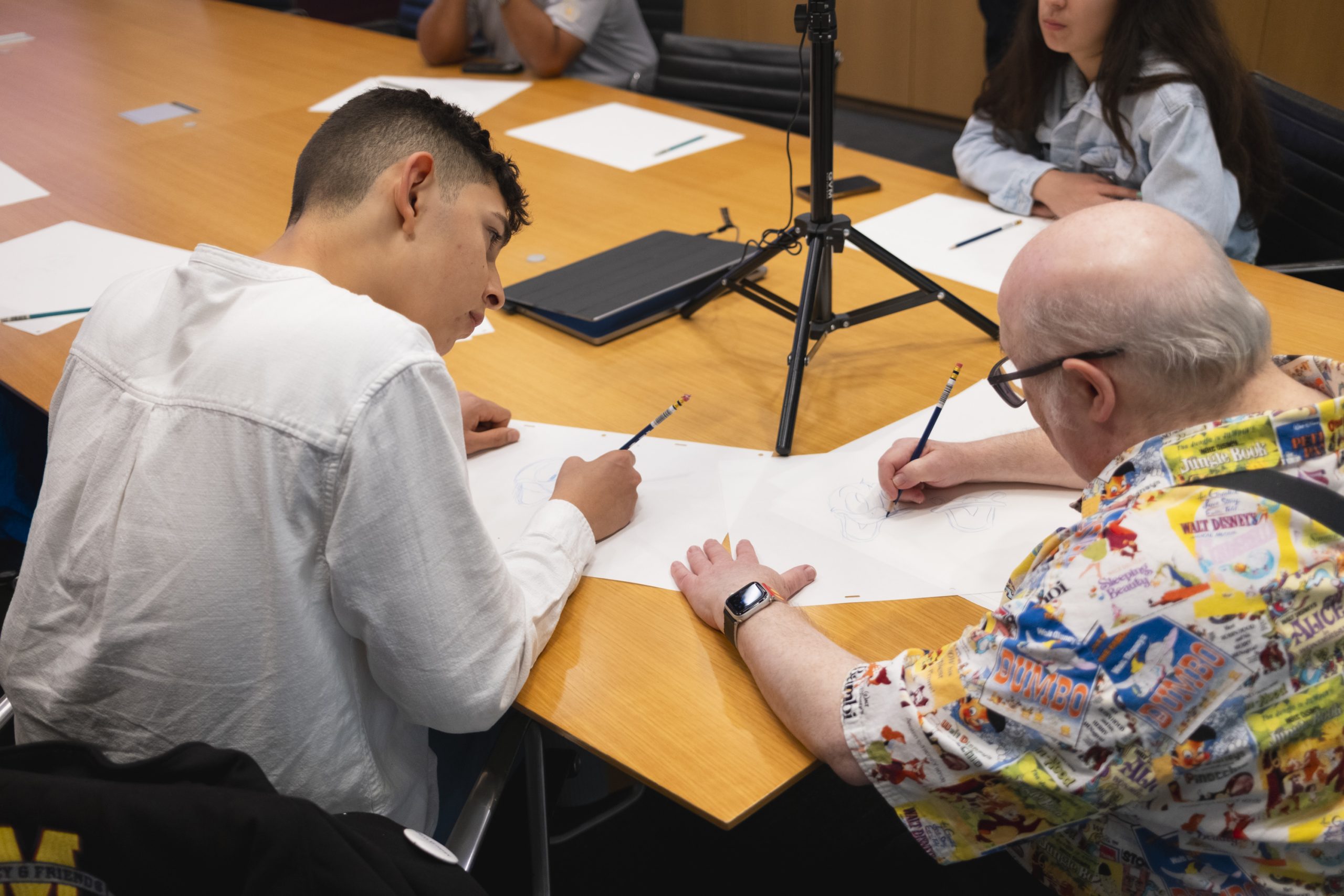 Disney employees work alongside a Make‑A‑Wish child during a hands‑on creative experience that reflects how Disney teams bring life‑changing wishes to life.