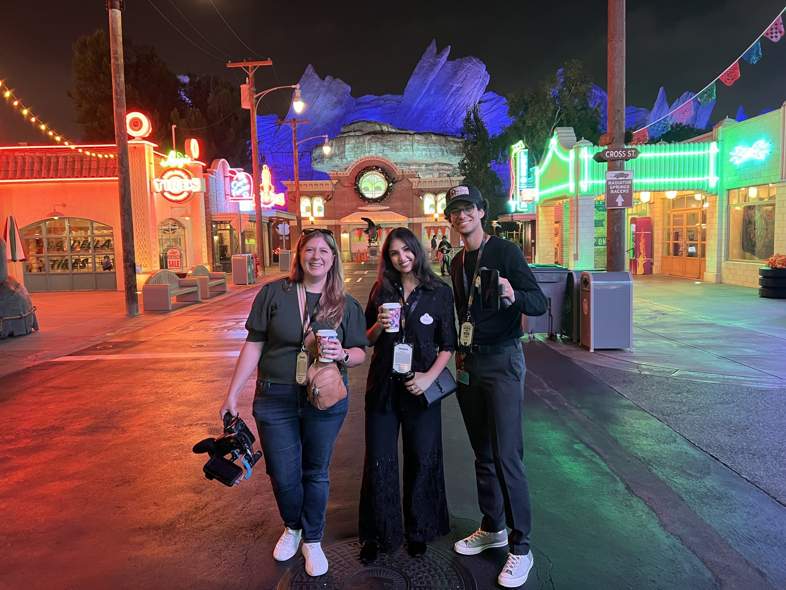 Disney employees stand together in a Disney park setting during Disney Week of Wishes, highlighting employee involvement in Make‑A‑Wish experiences.