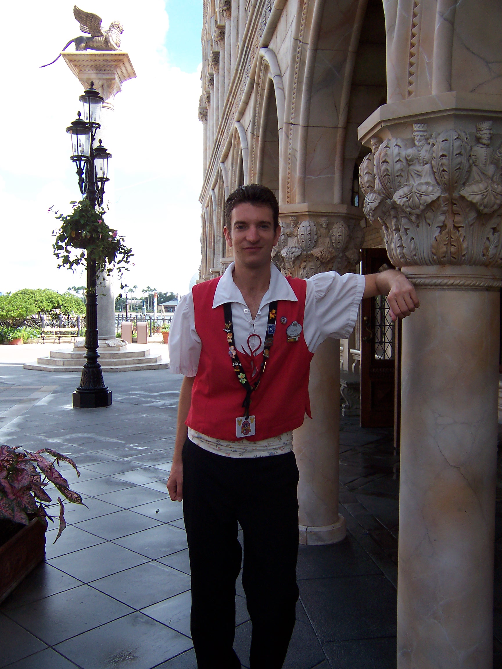 Disneyland Paris cast member leaning against wall outside.