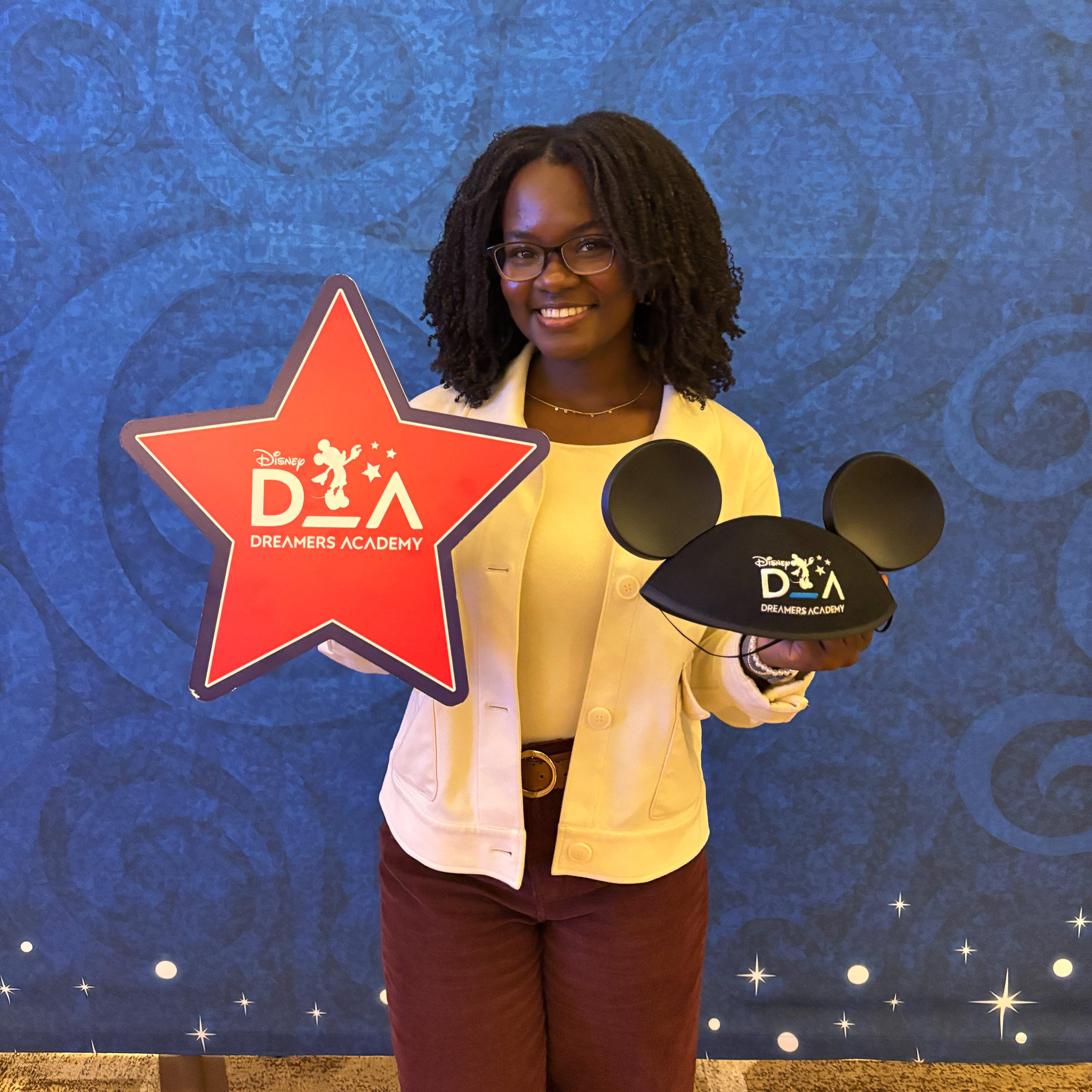April poses with a DDA sign and Mickey ears hat.