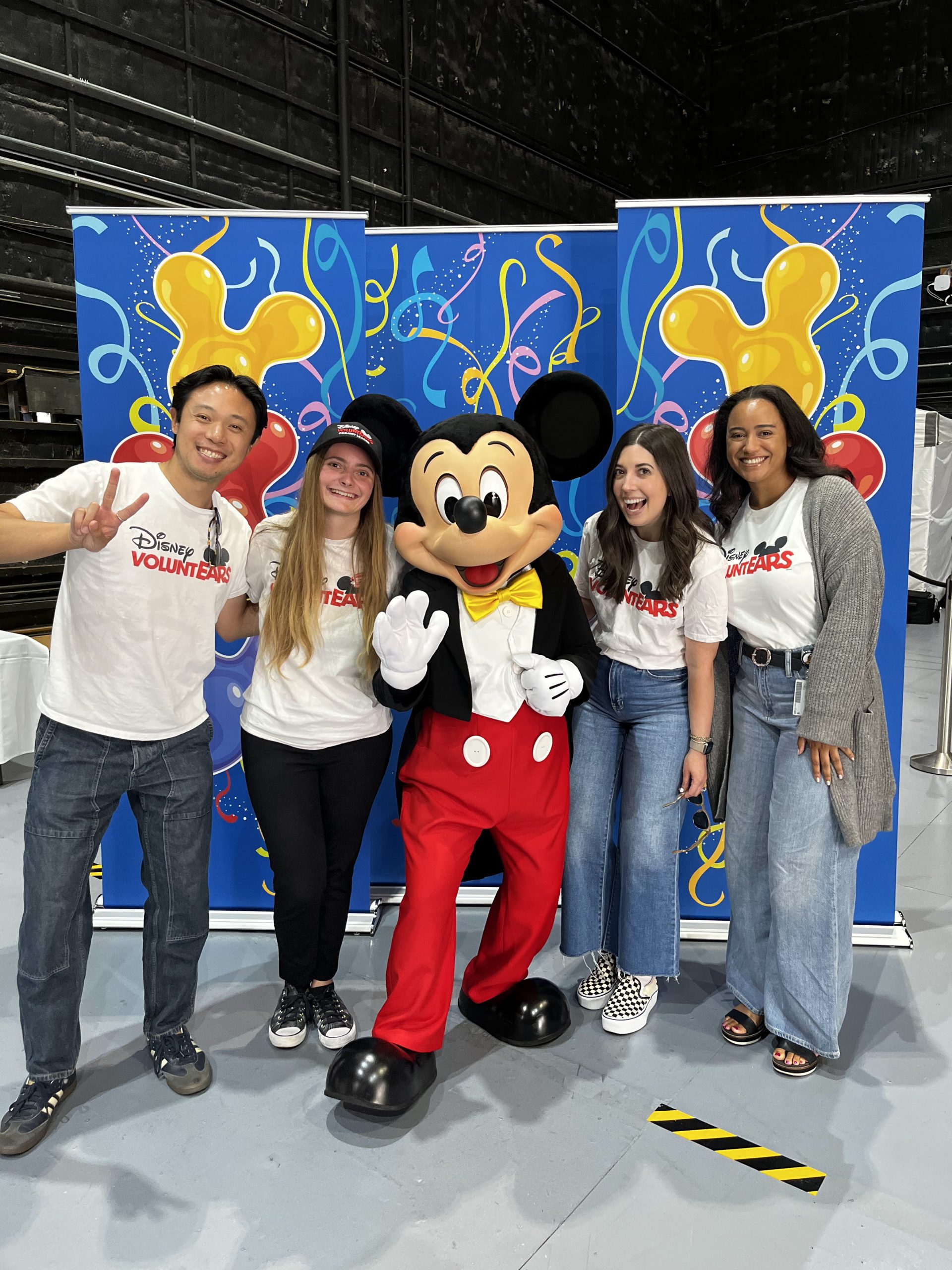 Disney volunteers pose with Mickey Mouse during Disney Week of Wishes, celebrating Disney&rsquo;s long‑standing partnership with Make‑A‑Wish.