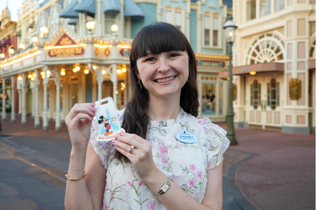 Sydney smiling at camera holding magnets she designed.