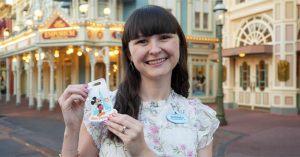 Sydney holding magnets she designed on Main Street.